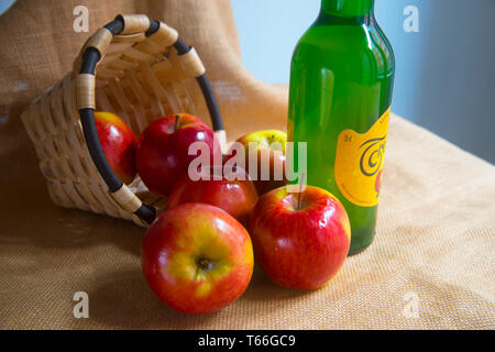 Sparse le mele e una bottiglia di sidro. Asturias, Spagna. Foto Stock