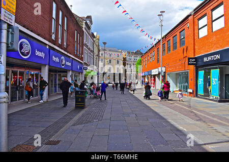 La gente camminare lungo Caroline Street, una delle principali strade dello shopping nella cittadina gallese di Bridgend, Foto Stock