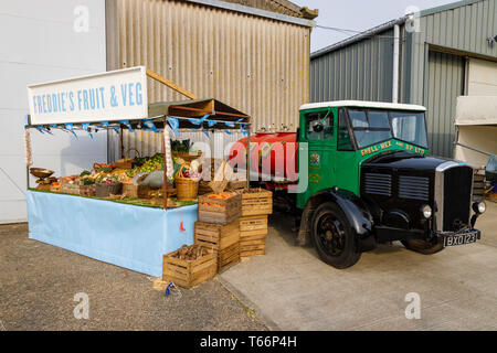 1935 Dennis Shell-Mex e BP autocisterna di carburante accanto a un tradizionale di frutta e verdura" stallo a la 77th Goodwood GRRC Assemblea dei Soci, Sussex, Regno Unito. Foto Stock