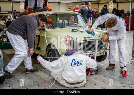Meccanica al lavoro sul 1964 Austin Mini Cooper S di Patrick Watts per il Betty Richmond Trophy gara. 77Th Goodwood GRRC Assemblea dei Soci, Sussex, Regno Unito Foto Stock
