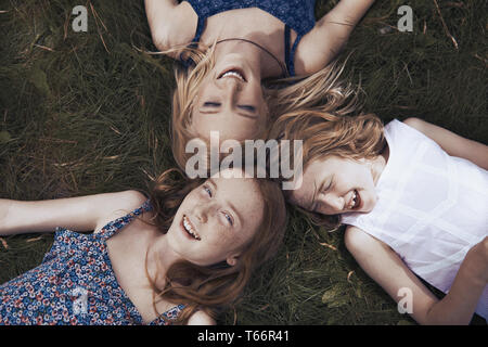 Ritratto felice sorelle posa in erba Foto Stock