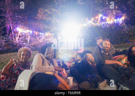 Happy amici godendo di filmato in cortile Foto Stock