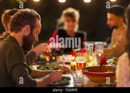 Gli amici di gustare la cena party in giardino Foto Stock