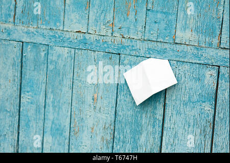 Foglio di carta sul vecchio blu sullo sfondo di legno. Foto Stock