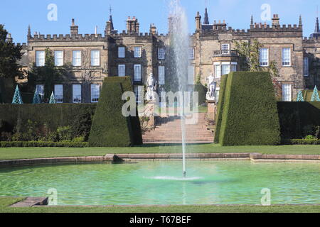Renishaw Hall visto dalla piscina attraverso il Taxus baccata (Yew) Topiaria da coperture in primavera, Derbyshire, England, Regno Unito Foto Stock