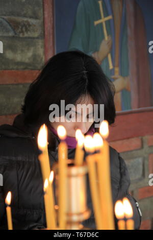 Bella giovane donna in preghiera nella chiesa Foto Stock