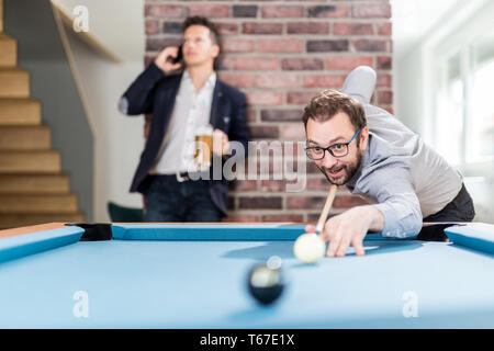 Business ragazzi giocare biliardo gioco di biliardo in ufficio stanza chill. Foto Stock