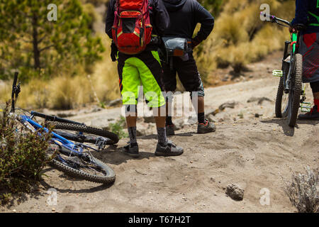 Un gruppo di tre amici la bicicletta sulla natura in piedi che guarda all'orizzonte. Foto Stock