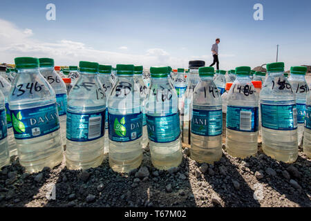 Bottiglie di acqua di campioni in un campo di fattoria in Pixley. Pur richiedendo molta acqua e livellati i campi agricoli e di moderni sistemi di irrigazione limitare gli sprechi. In generale, la coltivazione di ortaggi richiede solo una frazione di acqua che è necessaria per l'allevamento. Foto Stock