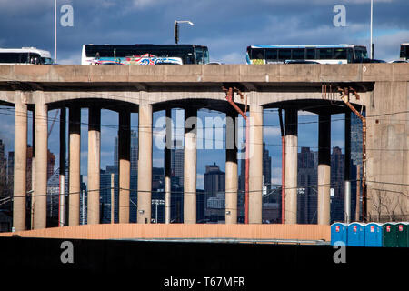 Una lunga fila di automobili e autobus sulla rampa che conduce al Lincoln Tunnel di Hoboken. Manhattan può essere visto in background. Foto Stock