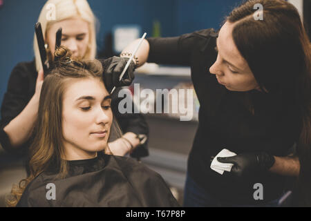 Professional Make Up Artist facendo fare fino in un salone di bellezza. Colorazione sopracciglia. vernici master sopracciglia con henna a bella ragazza, vernici con spazzola in s Foto Stock