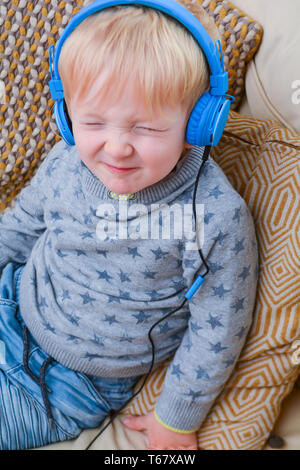 Bambino godendo ascoltando musica sulle cuffie Foto Stock