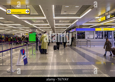 Piscina giallo luminoso segno di invito con un punto interrogativo e un cartello stradale su Airport e la stazione della metropolitana. Il passeggero in attesa sul punto di controllo Foto Stock