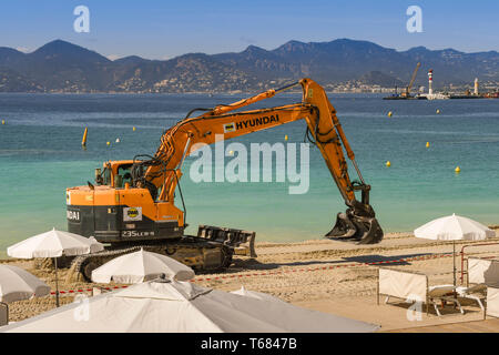 CANNES, Francia - Aprile 2019: Escavatore aggiunta di nuova sabbia della spiaggia di Cannes pronta per la primavera e l'estate stagione di vacanze Foto Stock