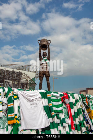 GLASGOW, SCOZIA - 29 Aprile 2019: la statua dell'icona celtica, Billy McNeill, circondato da sciarpe e magliette. Foto Stock