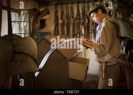 Vista laterale di un giovane uomo in una stalla. Foto Stock