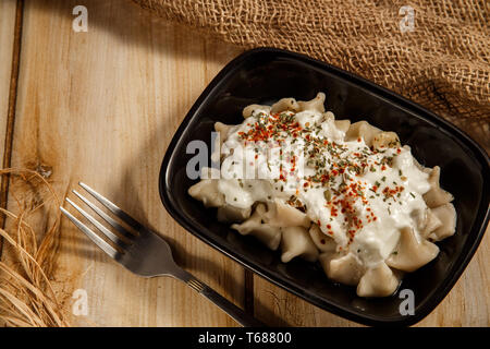 Bagno turco Manti manlama sulla piastra con il peperone rosso, il sugo di pomodoro, yogurt e menta Foto Stock