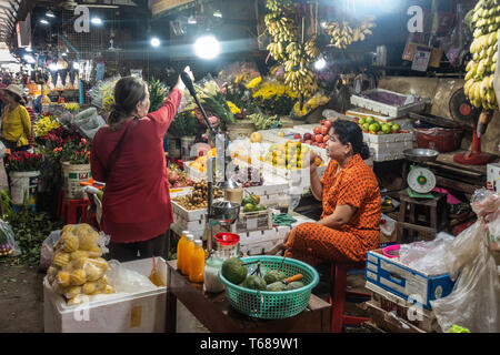 Sihanoukville, Cambogia - Marzo 15, 2019: Phsar Leu mercato. Il fornitore e client alla frutta stand di vendita visualizzati nelle caselle bianche. Foto Stock