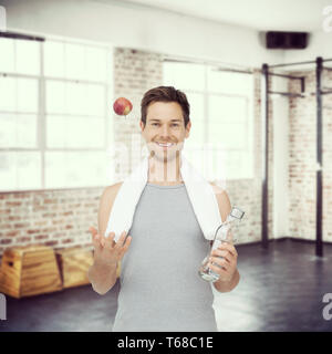 Immagine composita di sorridere montare giovane con Apple e una bottiglia d'acqua Foto Stock