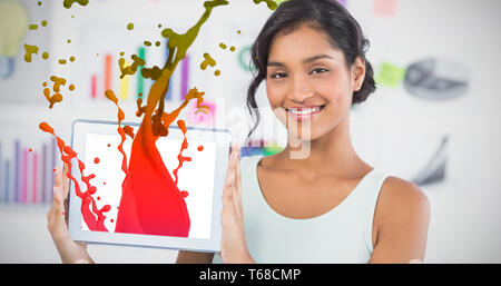 Immagine composita di felice imprenditrice che mostra digitale compressa in ufficio creativo Foto Stock