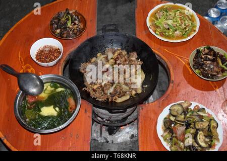 Cinese tradizionale pasto include molti piatti con differenti e delizioso cibo colorato. Cibi fatti in casa nella provincia di Guizhou in Cina. Foto Stock