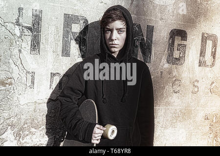 Vintage scatta di un ragazzo adolescente tenendo il suo bordo lungo Foto Stock