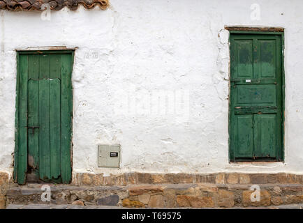 Due vecchi e danneggiati porte verdi in una strada della città coloniale di Villa de Leyva, nelle montagne andine della Colombia centrale. Foto Stock