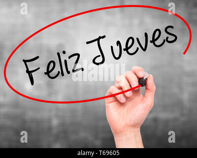 Man mano che scrive Feliz Jueves (Happy giovedì in spagnolo) con pennarello nero su schermo visivo. Foto Stock