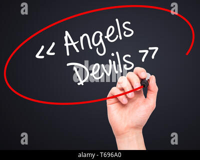 Man mano che scrive angeli - i diavoli con pennarello nero su schermo visivo. Foto Stock