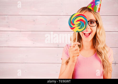 Immagine composita del ritratto di un hipster nasconde se stessa dietro un lecca-lecca Foto Stock