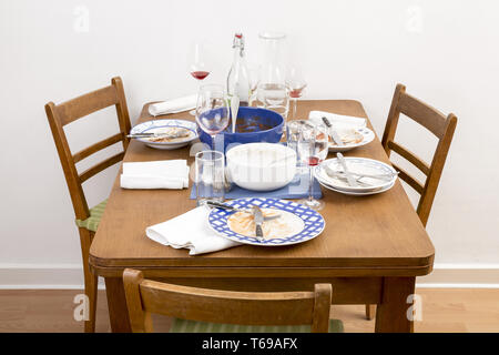 Tavolo con due sedie e i piatti sporchi su di esso Foto Stock