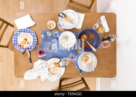 Tavolo con sedie e i piatti sporchi disposti su di esso Foto Stock
