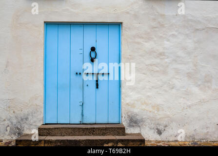 Blu pallido porta vecchia in una strada della città coloniale di Villa de Leyva, nelle montagne andine della Colombia centrale. Foto Stock