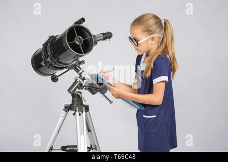 Ragazza giovane con gli occhiali scrive astronomo osservazioni Foto Stock