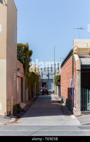 Pulitore di via macchinari di equitazione attraverso Melbourne nelle strade laterali. Foto Stock