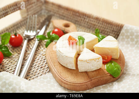 Delizioso formaggio brie con basilico e pomodori ciliegia sul vassoio Foto Stock