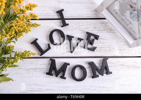 La frase "Io amo mamma' fatto di lettere sullo sfondo di legno. Il messaggio di saluto per la festa della mamma Foto Stock