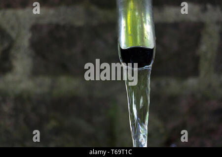 Close up di acqua che scorre da un rubinetto metallico Foto Stock