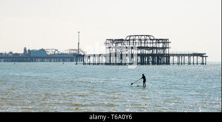 Brighton Regno Unito 30 aprile 2019 - Una racchetta boarder gode il caldo clima soleggiato off Hove spiaggia vicino al Molo Ovest questa mattina con la previsione di raggiungere in alta teens in alcune parti del sud est di oggi. Credito: Simon Dack/Alamy Live News Foto Stock