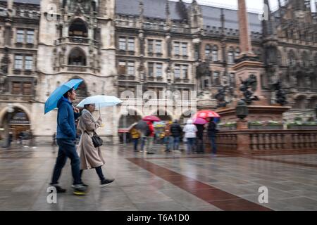 Monaco di Baviera, Germania. 30 apr, 2019. I turisti cross Marienplatz quando piove. Credito: Sina Schuldt/dpa/Alamy Live News Foto Stock