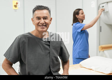 Ritratto di Felice Senior Uomo sorridente come paziente in ospedale Foto Stock