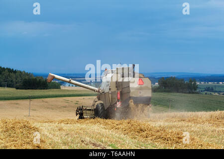 Vecchia mietitrebbia su campo oro raccolto di frumento Foto Stock