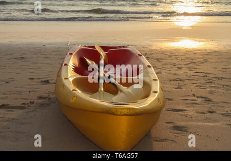 Canoa Kayak barca sulla spiaggia durante il tramonto Foto Stock