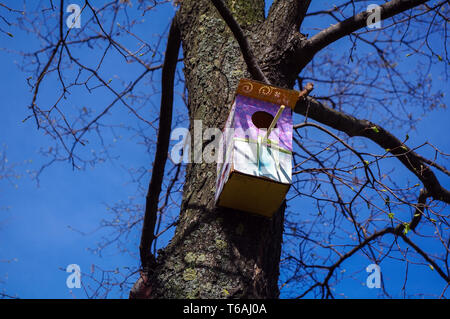 Colorato di rosa modellato birdhouses in legno su un albero. Foto Stock