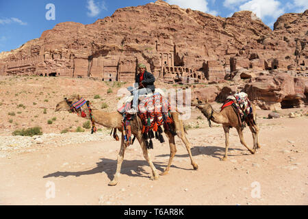 Un uomo beduino in sella al suo cammello nell'antica città di Petra, Giordania. Foto Stock