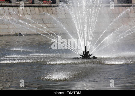 Uno spruzzo di acqua dalla fontana nel mezzo del fiume Foto Stock