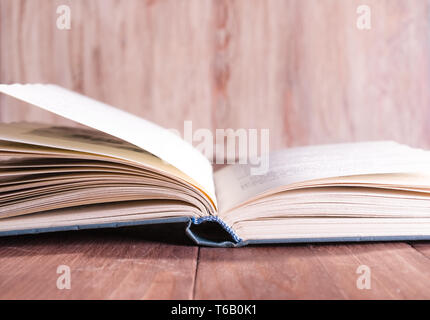 Aprire il libro che giace su di un tavolo di legno Foto Stock