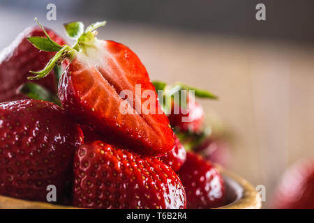 Succose fragole lavate in ciotola di legno sul tavolo da cucina Foto Stock