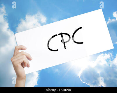 CPC (costo per clic) firmare su carta bianca. Man mano che tiene la carta con testo. Isolato su sfondo cielo Foto Stock