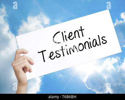 Client Testimonials Firma su carta bianca. Man mano che tiene la carta con testo. Isolato su sfondo cielo Foto Stock